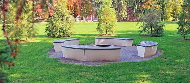 Image of Susquehannock Tribute Circle at Susquehanna University. Fire pit surrounded by four uniquely shaped, circular benches.